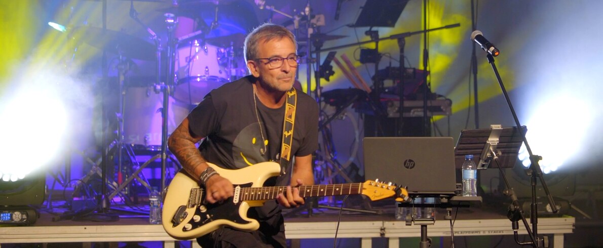 Marcelo Russo tocando la guitarra sobre un escenario